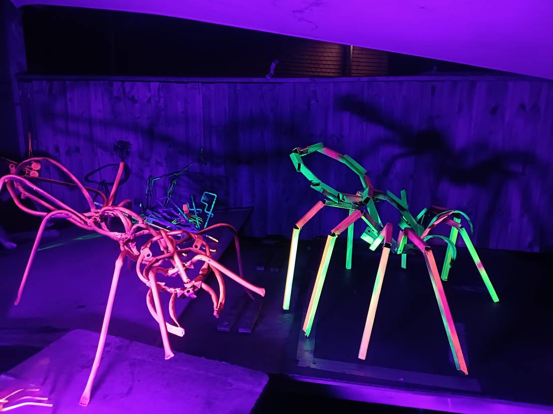 Two welded creatures lit in pink and green UV